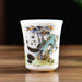 Three ceramic cups with artistic designs on a wooden surface