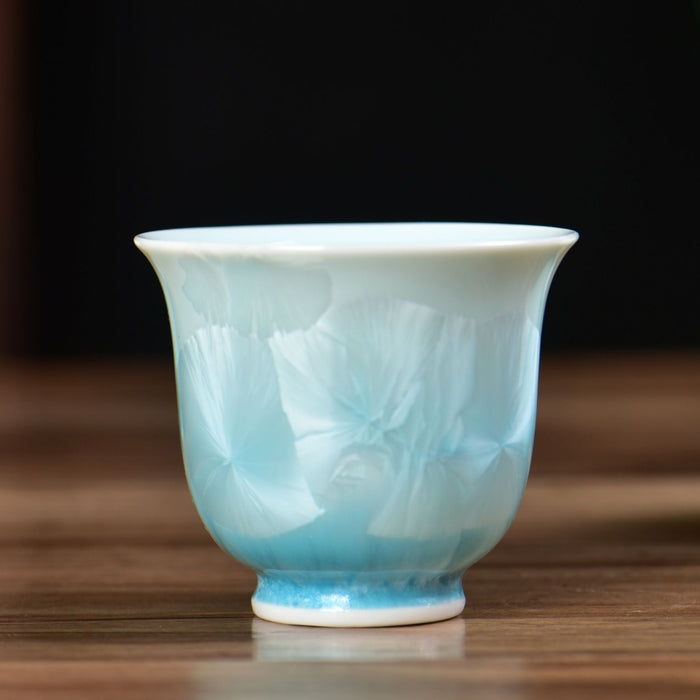 Teal ceramic cups on a wooden surface with a blurred background